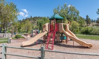 Outdoor children's playground with two slides and woodchips